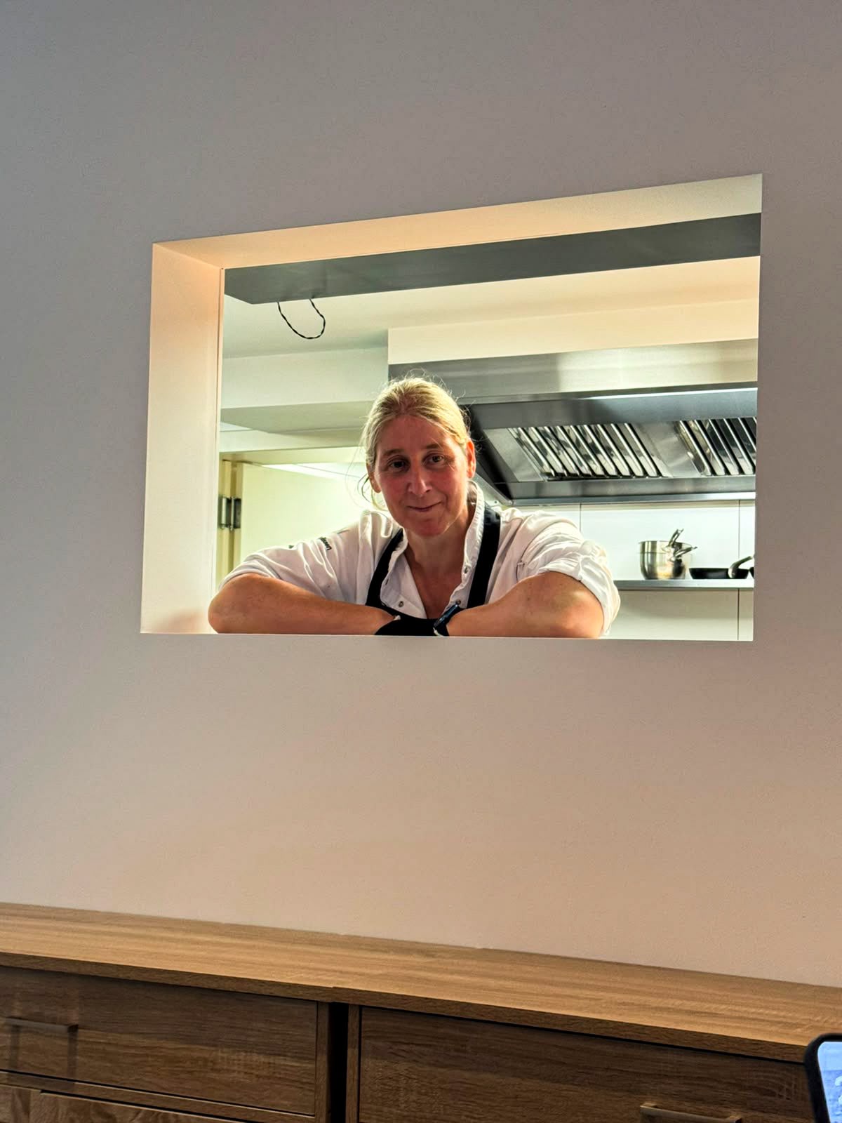 An Nelissen aan het doorgeefluik van de open keuken